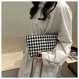 Detail of houndstooth toiletry bag featuring premium knitted texture and compact design
