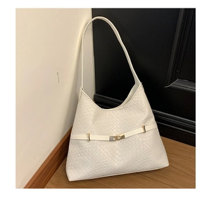 Detail shot of white woven texture on a hobo shoulder bag with a gold buckle clasp