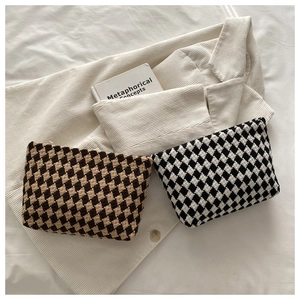 Detail of the high-quality woven checkerboard clutch bag with durable top zipper closure