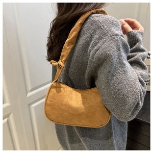 Détail du sac d'épaule en velours côtelé camel avec bandoulière à nœud élégant