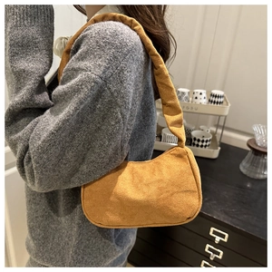 Détail d'un sac à bandoulière en daim jaune moutarde avec design plissé et texture élégante