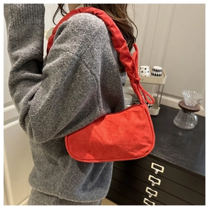 Vue détaillée du sac à bandoulière en daim rouge avec plis et nœud élégant