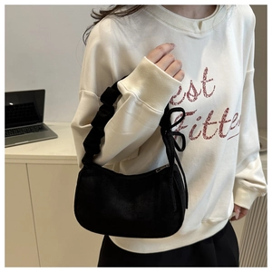 Détail du sac croissant en velours noir avec poignée plissée et décor de nœud papillon