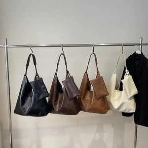 Minimalist hobo tote bag in four colors with inner pouch hanging on a metal rack