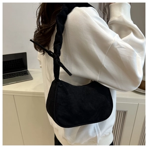 Détail du sac à main en daim plissé noir avec bandoulière nouée et fermeture éclair en métal