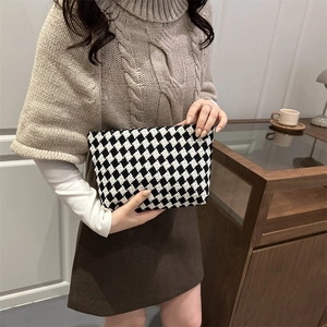 Classic black and white checkered knit clutch bag with zipper closure for autumn fashion