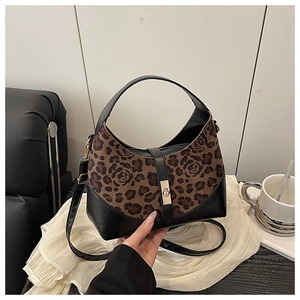 Detail of vintage bucket bag featuring leopard rose print and golden twist lock buckle