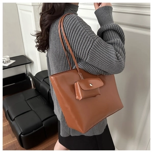 Detail of caramel leather tote bag set with matching mini pouch charm and matte finish