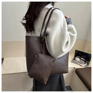Detail of dark brown faux leather tote bag with a matching small hanging zipper pouch