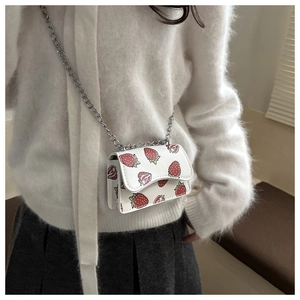 Detail of white mini crossbody bag with strawberry print and silver chain strap