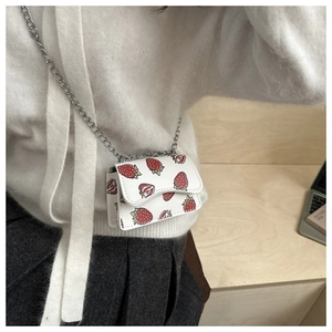 Detail of white mini crossbody bag with strawberry print and silver chain strap