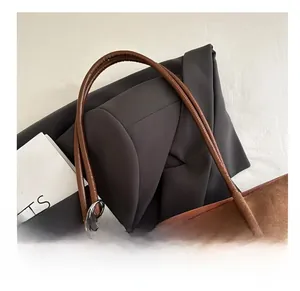 Detail of vintage brown suede tote bag with round leather handle and decorative beads