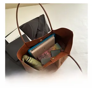 Top view of spacious brown suede tote bag interior showing laptop and daily essentials