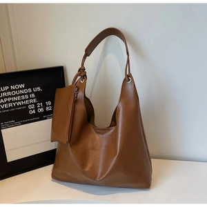 Detailed macro view of brown faux leather tote bag with silver metal ring and zipper pouch