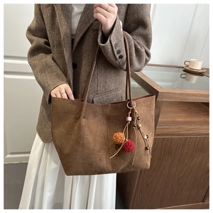 Brown suede tote bag detail with colorful pom-pom and wooden bead vintage charms