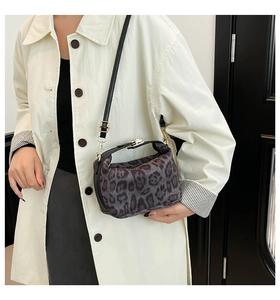 Détail du sac bandoulière léopard avec boucles dorées et sangle réglable sur modèle