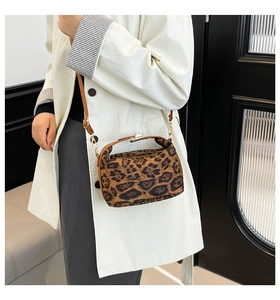 Détail du mini sac léopard avec bandoulière en cuir marron et boucle en métal doré