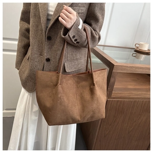 Detail of vintage brown suede tote bag with long shoulder strap styled for commuting