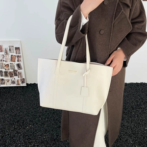 Retro cream white oversized leather tote bag with shoulder straps shown on a model