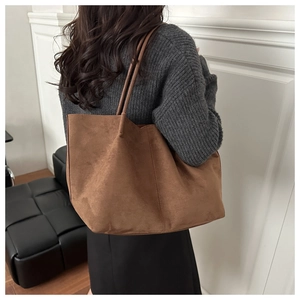 Detailed side view of a large brown suede tote bag worn on shoulder for commuting