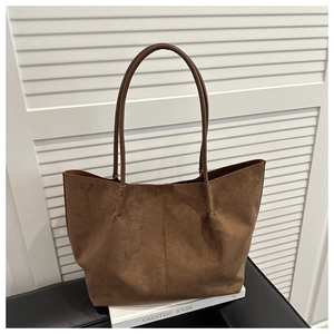 Detail view of brown suede tote bag featuring center seam and matte leather texture
