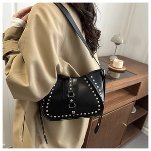 Detail of black rivet saddle bag with silver studs and metal ring on a shoulder strap