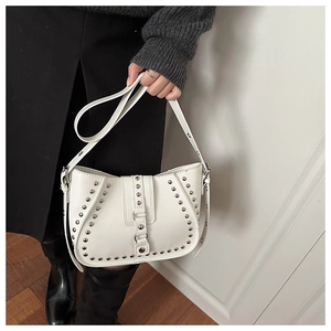 Detail of white saddle bag with silver rivets and adjustable strap in modern urban style