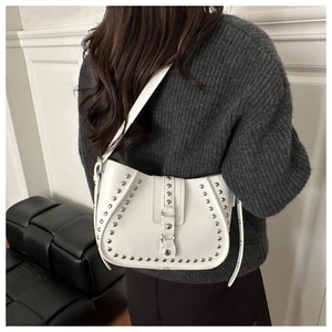 Close-up of a white leather crescent bag featuring silver studs and motorcycle style detail