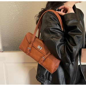 Détail du sac baguette vintage marron caramel avec boucles argentées et deux anses