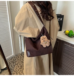 Détail du sac cabas en suédine marron foncé avec bandoulière en cuir et charm ourson