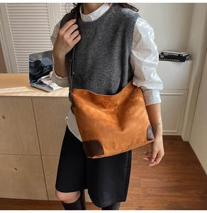 Détail du sac cabas minimaliste en daim marron avec renforts contrastés en cuir foncé