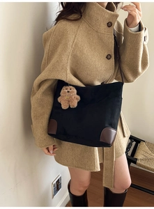 Détail du grand sac cabas noir en toile avec coins en cuir marron et pendentif ours