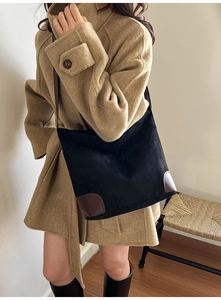 Détail du sac seau en daim avec bordure en cuir porté avec un manteau d'hiver élégant