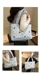 Borsa tote trapuntata azzurra con ricami a fiocco nero e ciondolo in argento
