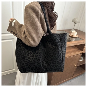 Vue détaillée d'un grand sac cabas léopard porté par un mannequin dans un décor rétro chic