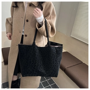 Detail of large leopard print tote bag in dark plush fabric styled with a wool coat