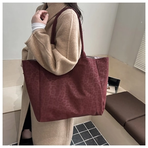 Détail macro du sac cabas en daim bordeaux à imprimé léopard avec sa bandoulière