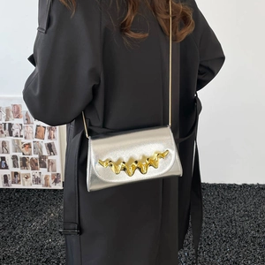 Silver glossy crossbody bag with wavy gold metal decor and slim gold chain strap