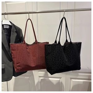 Close-up of black and burgundy leopard print tote bags with long handles for daily commuting