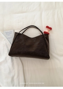 Borsa tote minimalista in pelle morbida marrone scuro con dettaglio ciondolo peluche