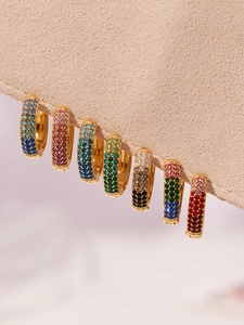 Detalle de pendientes huggie de acero inoxidable con circonitas de colores en degradado