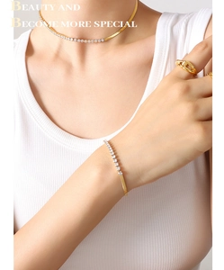 Detail of gold-plated snake chain necklace and bracelet set with cubic zirconia stones