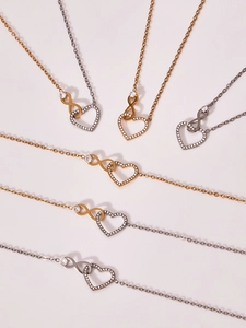 Dettaglio delle collane con cuore e infinito in oro, argento e nero con zirconi incastonati