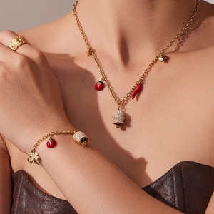Parure de bijoux dorés avec pendentifs piment et coccinelle sur collier et bracelet