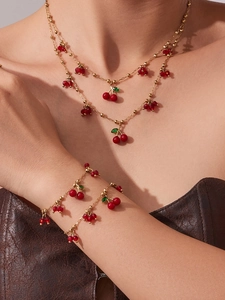 Dettaglio del set collana e bracciale con pendenti a ciliegia placcati oro 18 carati