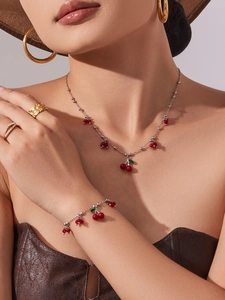 Dettaglio del set gioielli ciliegia rossa con collana e bracciale su una modella