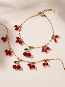 Dettaglio del bracciale con ciliegie in acciaio inossidabile dorato e perline