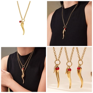 Detail of 18k gold chili pendant with red ladybug charm and sparkling zircon accents