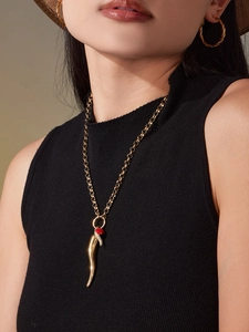 Detail of 18k gold plated chili pendant necklace and twisted hoop earrings on model