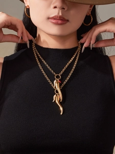 Detail of double-layer gold Corno necklace and textured hoop earrings on model